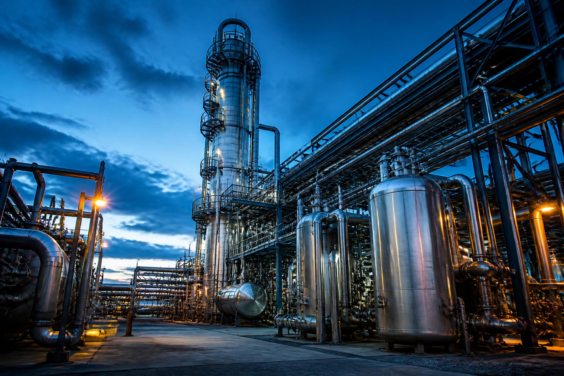 Industrial process plant with stainless steel piping racks at blue hour